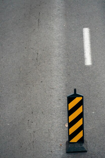 Una señal de tráfico que indica la separación de los flujos de tráfico frente a un tramo peligroso de la carretera durante los trabajos de reparación Delineador del separador de carreteras