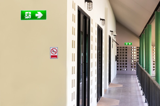 Foto señal verde de salida de emergencia para instalar sobre la construcción del edificio de la puerta que muestra la forma de escapar