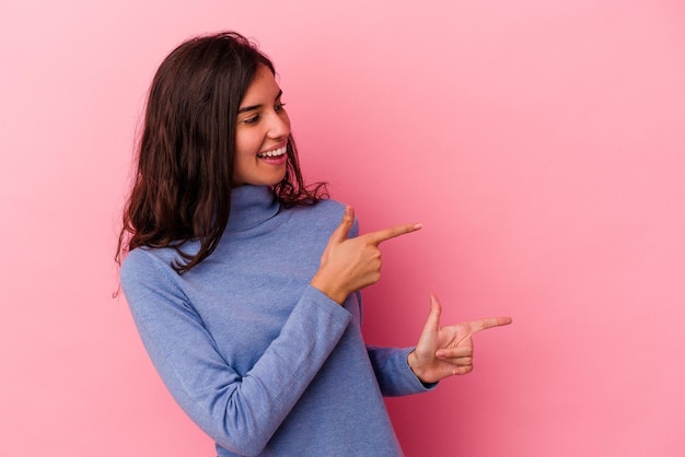 Señala con el dedo pulgar lejos riendo y despreocupado