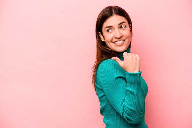 Señala con el dedo pulgar lejos riendo y despreocupado