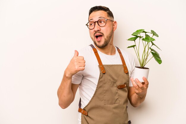 Señala con el dedo pulgar lejos riendo y despreocupado