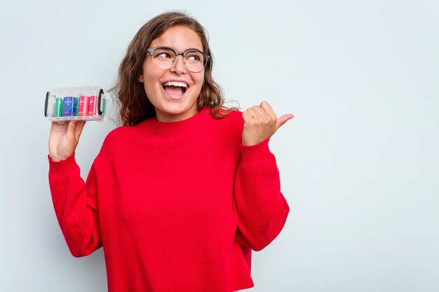 Señala con el dedo pulgar lejos riendo y despreocupado