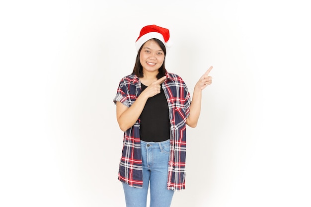 Señalando y presentando a un lado de la hermosa mujer asiática vestida con camisa a cuadros roja y gorro de Papá Noel
