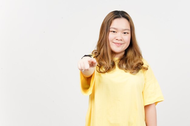 Señalándote a ti y sonriendo a una hermosa mujer asiática con camiseta amarilla aislada en blanco