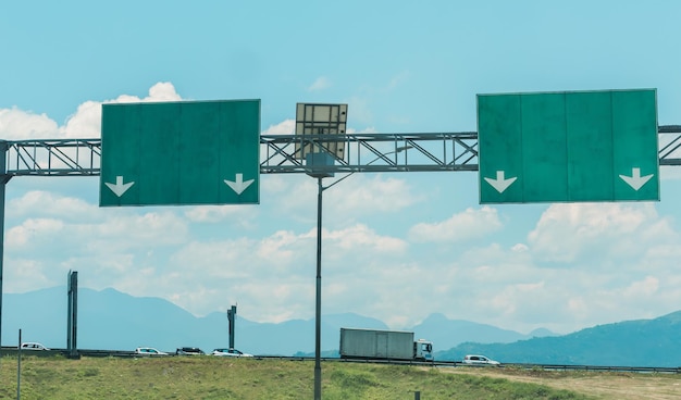 Señales de autopista junto a la autopista con montañas en el fondo concepto de transporte rural