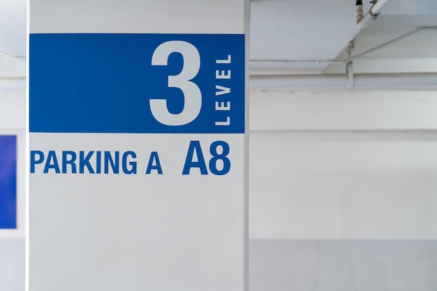 La señalización en el poste de estacionamiento interior le dice al conductor qué camino tomar y la ubicación en el estacionamiento