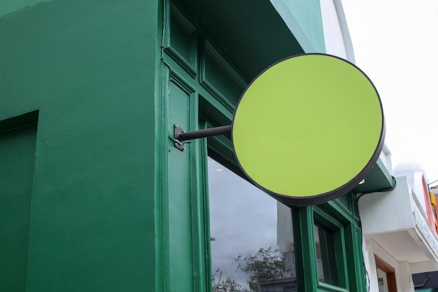 Señalización de tienda redondeada en blanco para maqueta Señalización redondeada colgada en la pared verde