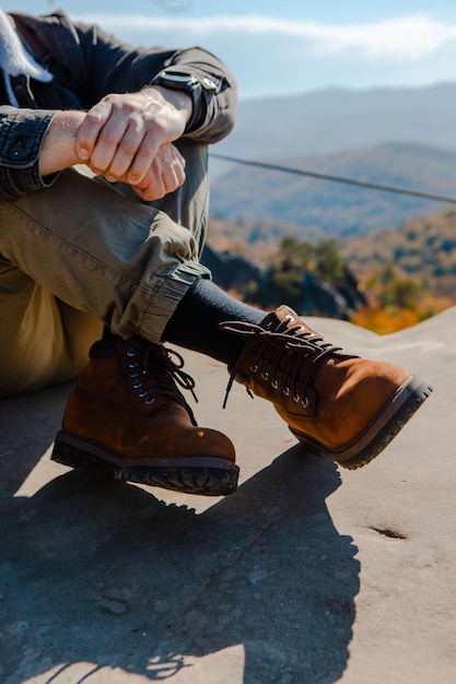 Foto senderismo concepto hombres piernas en botas sobre la roca