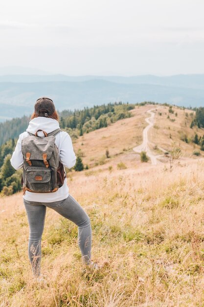 Senderismo concepto mujer con mochila en el pico de las montañas