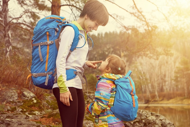 Senderismo feliz madre y niña viajando con mochilas