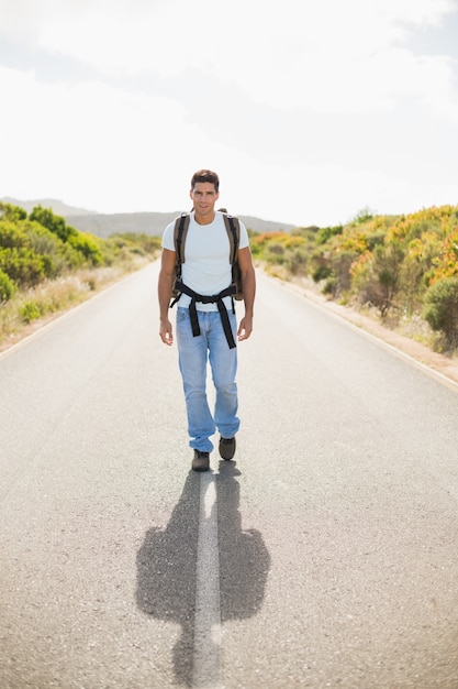 Senderismo hombre caminando por la carretera de campo