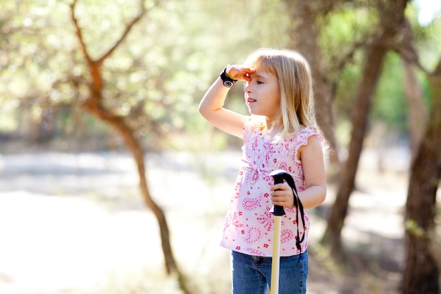 Senderismo niño niña buscando mano en cabeza en el bosque