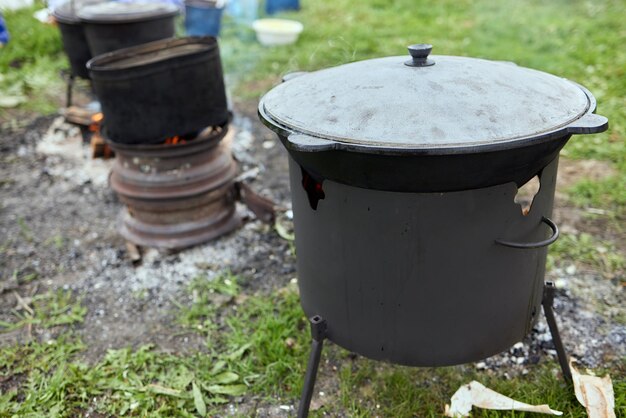 Senderismo pot Bowler en la hoguera en caldero en la hoguera Viajar turismo picnic cocinar cocinar en la hoguera en un caldero fuego y humo