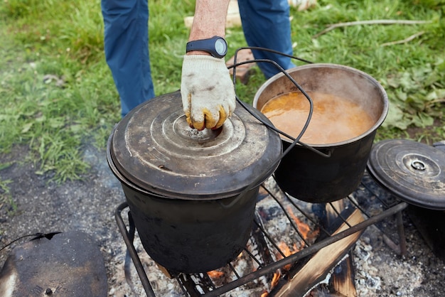 Senderismo pot Bowler en la hoguera en caldero en la hoguera Viajar turismo picnic cocinar cocinar en la hoguera en un caldero fuego y humo