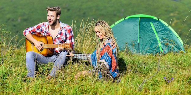 Senderismo romance Camping en las montañas Aire fresco y sentimientos puros Pareja enamorada feliz relajante naturaleza fondo Novio novia guitarra cerca de la tienda de campaña Vacaciones de verano Vacaciones de camping