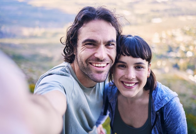 Senderismo selfie y retrato de pareja en la naturaleza para vacaciones de aventura y viaje en la montaña Citas de viaje y hombre y mujer felices toman fotos para caminatas en las redes sociales y recuerdos saludables