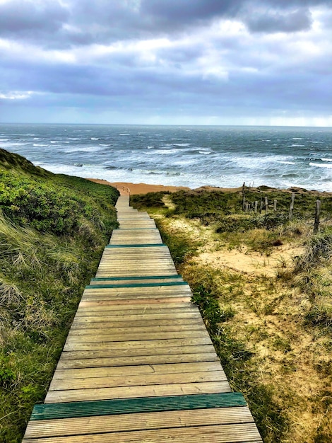 Un sendero que conduce hacia el mar contra el cielo