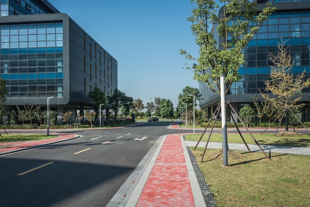 Foto sendero vacío con exterior moderno edificio de oficinas y azul cielo nublado durante el amanecer