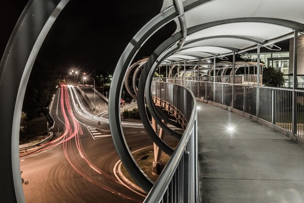 Foto senderos de luz en el puente peatonal en la ciudad por la noche