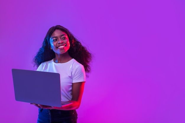 Foto senhora afro-americana usando laptop para educação de trabalho on-line ou comunicação olhando para o espaço vazio