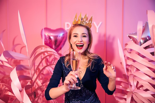 Senhora alegre glamorosa segurando uma taça de champanhe