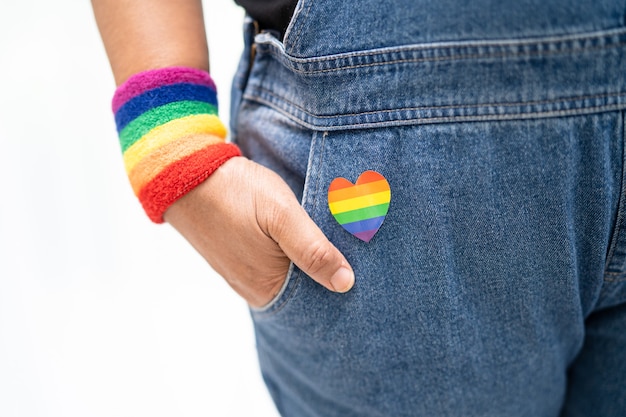 Senhora asiática usando pulseiras com a bandeira do arco-íris, símbolo do mês do orgulho LGBT, comemora anualmente em junho a socialização dos direitos humanos de gays, lésbicas, bissexuais, transgêneros.
