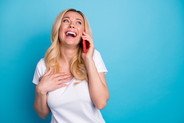 senhora atraente e surpresa segurando conversa ao telefone rindo