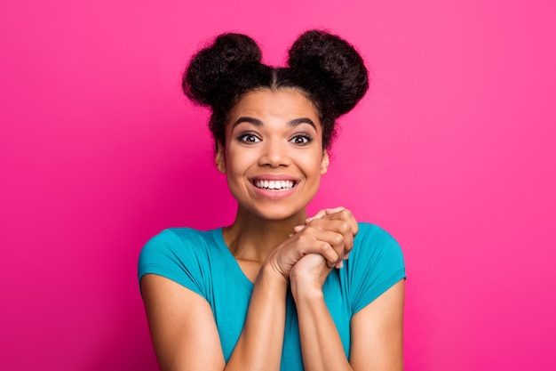 Senhora bonita de pele escura com pãezinhos junta os braços, surpresa, divirta-se no fundo rosa