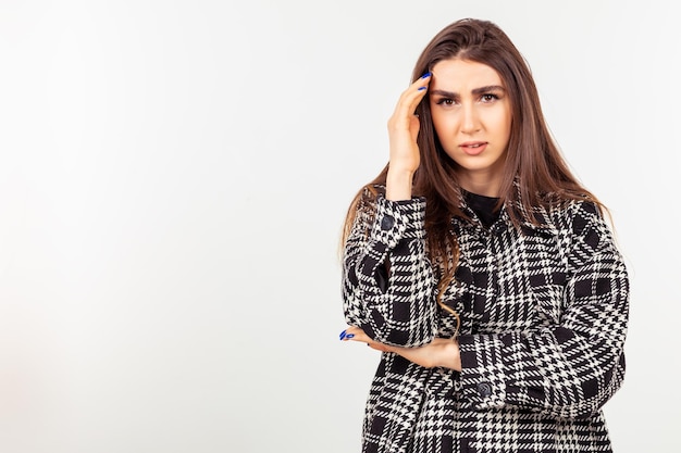 Senhora chateada fica em fundo branco e olhando para a câmera