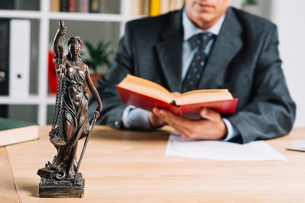 Foto senhora da justiça em frente a justiça masculina lendo o livro de lei