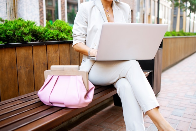 Foto senhora de negócios elegante trabalhando ao ar livre com seu laptop