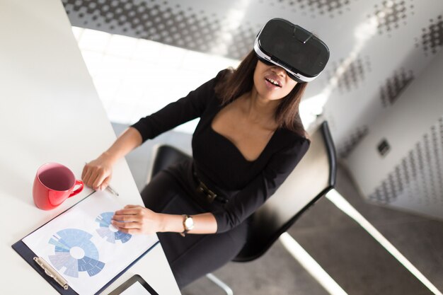 Foto senhora de negócios jovem bonita suíte forte preto sentar à mesa do escritório em copos de vr