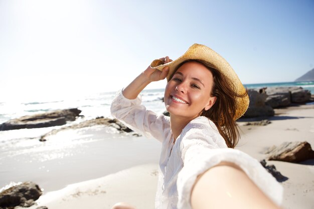 Senhora despreocupada de férias na praia tomando selfie