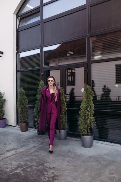 Senhora elegante terno roxo andando na rua.