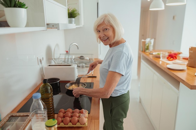 Senhora idosa cozinhando na cozinha em casa