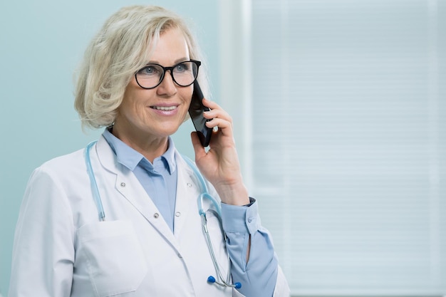 Senhora médica fornece consultas em smartphone do escritório