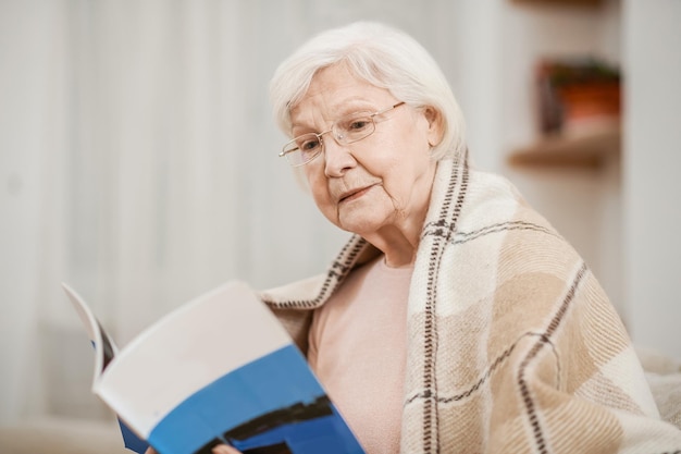 Senhora sênior calma absorta em um livro