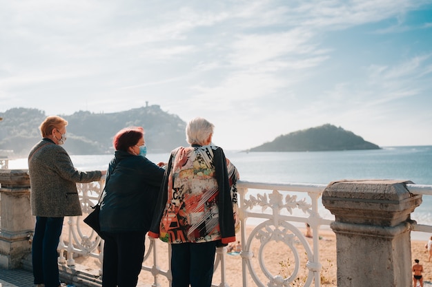 Foto senhoras aposentadas olhando para a praia de la concha em san sebastian