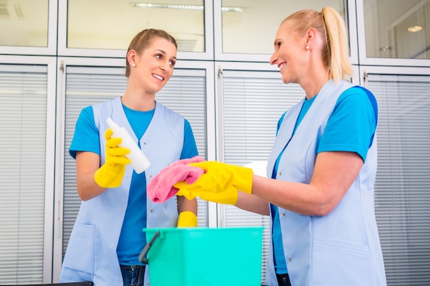 Senhoras da equipe de limpeza comercial trabalhando em equipe no escritório