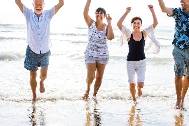 Sênior amigos brincando na praia