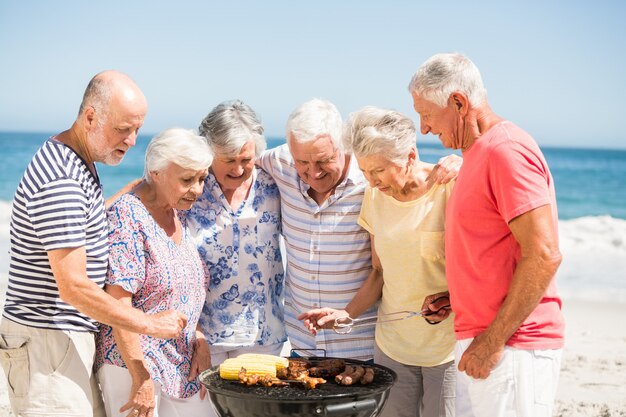 Senior con una barbacoa en la playa