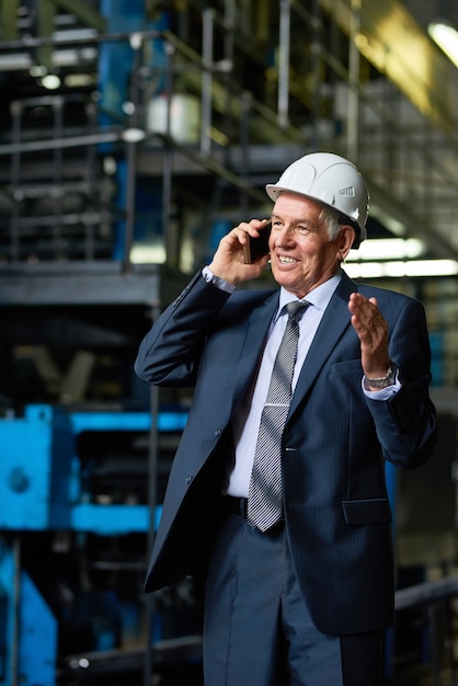 Senior Businessman telefonisch in der Fabrikwerkstatt