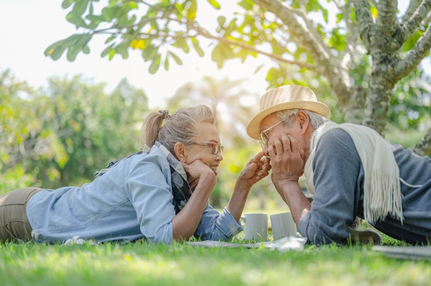 Sênior, casais, aposentadoria, seguro, idosos, conceito de estilo de vida. Casais idosos conversando no gramado ao ar livre pela manhã sobre planos de seguro de vida com um conceito de aposentadoria feliz.