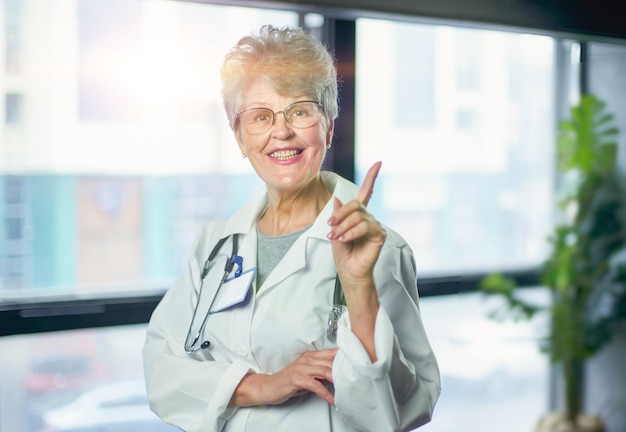 Senior doctora sonriendo en el hospital