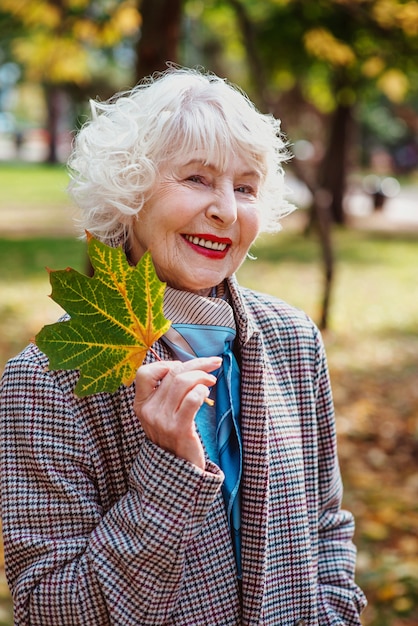 Senior elegante stilvolle modische Frau im Mantel im Freien im Herbstpark Alter Jahreszeiten fallen