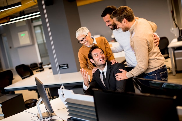 Senior empresaria trabajando junto con jóvenes empresarios en la oficina