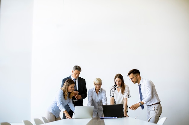 Senior empresaria trabajando junto con jóvenes empresarios en la oficina