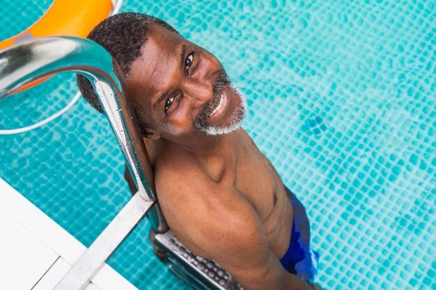 Foto sênior feliz fazendo uma festa na piscina