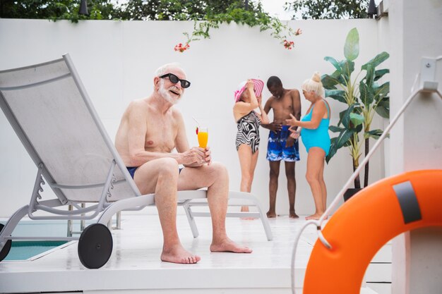 Sênior feliz fazendo uma festa na piscina