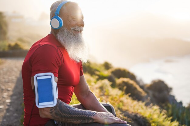 Senior fit hombre al aire libre al atardecer después de la sesión de entrenamiento